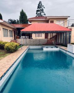 uma piscina em frente a uma casa com telhado vermelho em Quinta Estefanía, Paute-Uzhupud em Cuenca