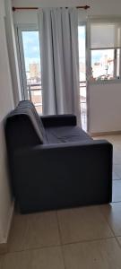a black couch in a room with a window at La lunita 1 in Córdoba
