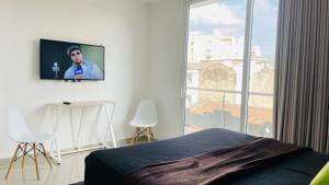 a bedroom with a tv hanging on the wall at Aparta estudio el peñón 4.3 in Cali