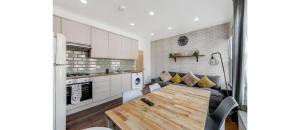 a kitchen and living room with a table and a couch at Spacious Two Bedroom Apartment in Wood Green in London