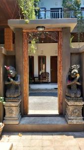 a mirror with two statues in front of a building at Genta House in Kuta