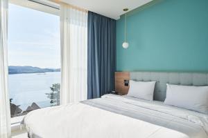Postel nebo postele na pokoji v ubytování Yeosu Calacatta Hotel & Resort