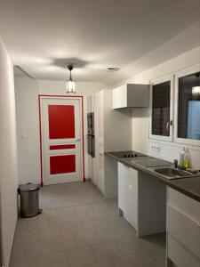 a kitchen with a red door in the middle of it at Gîte Echelle in Saint-Omer