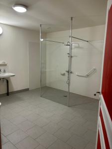 La salle de bains est pourvue d'une douche avec une porte en verre. dans l'établissement Gîte Echelle, à Saint-Omer