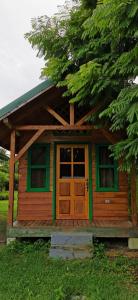une petite cabine avec une porte en bois dans l'herbe dans l'établissement Casitas Jacaranda, à Savegre