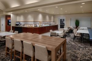 a restaurant with a large wooden table and chairs at Residence Inn East Rutherford Meadowlands in East Rutherford