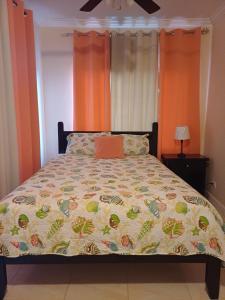 a bed in a bedroom with an orange wall at Da Bottom in Curtis