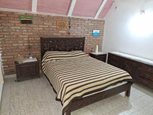 een groot bed in een kamer met een bakstenen muur bij Paraíso de Mayú in San Antonio de Arredondo