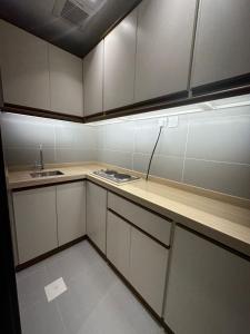 a small kitchen with white cabinets and a sink at فندق كنان العزيزية Kinan Al Azizia Hotel Makkah in Mecca