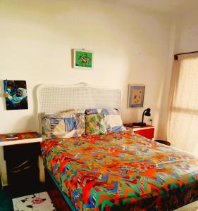 a bedroom with a bed with a colorful comforter at Los Pinos condominio piso 2 in Zorritos