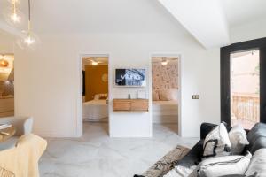 uma sala de estar com paredes brancas e um sofá em En Calma por el Mediterráneo. em Sant Adria de Besos