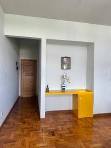 Zimmer mit gelbem Schreibtisch in einer weißen Wand in der Unterkunft Apartamento BH Centro-Sul in Belo Horizonte