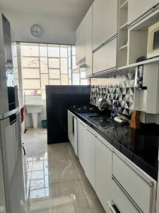 eine Küche mit weißen Schränken und einem Waschbecken in der Unterkunft Apartamento BH Centro-Sul in Belo Horizonte