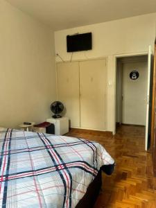 ein Schlafzimmer mit einem Bett und einem TV an der Wand in der Unterkunft Apartamento BH Centro-Sul in Belo Horizonte