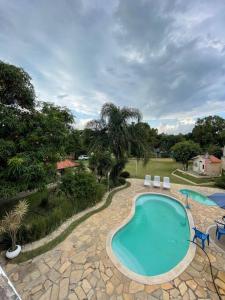 uma vista superior de uma piscina com duas cadeiras em Chácara Cantinho Castanheira a 40 min de SP prox Itu e Sorocaba em Itu