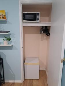 un microondas sentado en un estante en un armario en Paradise Escape On The Lake, en Perth