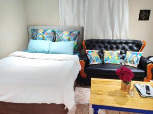 um quarto com uma cama, um sofá e uma mesa em Zikora em Pretoria