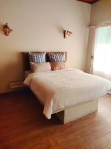 a bedroom with a large bed with white sheets and pillows at Zulia home in Pretoria