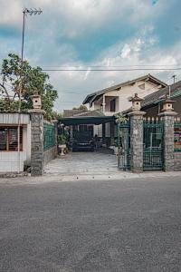 a house with a driveway with a gate and a car at Griyo Kiswo Vacation Home in Lawean +40 photos