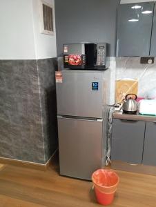 a kitchen with a microwave on top of a refrigerator at 10Pax Deluxe Apartment , CloudView Snoopy Theme, Amber Court, Genting Highlands in Genting Highlands