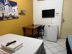 a room with a bed and a desk and a television at Solar dos Poetas in São Luís