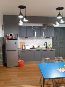 eine Küche mit blauen Schränken und einem blauen Tisch in der Unterkunft 10Pax Deluxe Apartment, CloudView Snoopy Theme, Golden Hills Resort Genting, Formerly Known as Amber Court in Genting Highlands