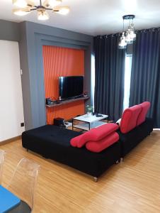 a living room with a black couch and red pillows at 10Pax Deluxe Apartment , CloudView Snoopy Theme, Amber Court, Genting Highlands in Genting Highlands