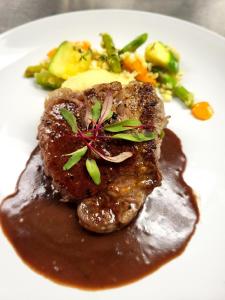 um prato de alimentos com carne, molho e legumes em Channel Bass Inn and Restaurant em Chincoteague