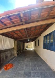 康塞桑達巴拉的住宿－Casa em Conceição da Barra para temporada e Carnaval，一座空的走廊,在楼房下面有一个橙色的软管