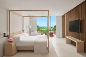 a bedroom with a large white bed and a tv at The Riviera Maya EDITION at Kanai in Playa del Carmen