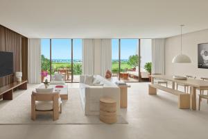 a living room with white furniture and large windows at The Riviera Maya EDITION at Kanai in Playa del Carmen
