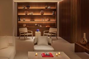 a living room with a couch and chairs and shelves at The Riviera Maya EDITION at Kanai in Playa del Carmen