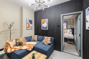 a living room with a blue couch and a bedroom at Modern & Funky 3-BR Duplex with Games Room & Sauna in London