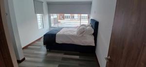 1 dormitorio con 1 cama en una habitación con ventana en CasAvella Paipa en Paipa