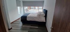 a bedroom with a bed in a room with a window at CasAvella Paipa in Paipa