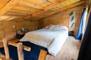 1 dormitorio con 1 cama en una cabaña de madera en Cabaña Colibrí, en Santa Cruz Verapaz