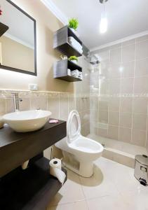 y baño con aseo blanco y lavamanos. en Apartamento en la mejor ubicación, centro de Loja, en Loja