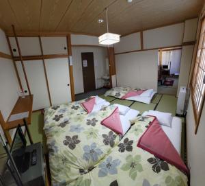 a room with three beds in a room at Sunshine Kyohei in Nozawa Onsen