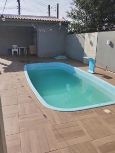 a large blue swimming pool in a yard at Casa em imbé in Imbé