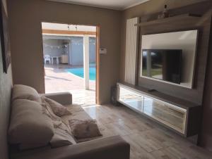 a living room with a couch and a large mirror at Casa em imbé in Imbé