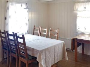 a dining room table and chairs with a white table and window at Holiday home VEGA II 
