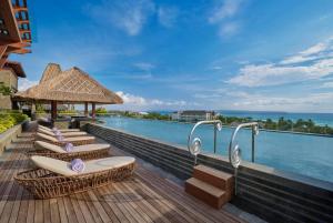 a row of surfboards sitting on a deck next to the ocean at Holiday Inn Resort Bali Canggu by IHG in Canggu