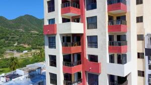 a tall building with red balconies on it at Apartamento Vista azul rodadero Laureles 801 in Rodadero