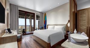 a bedroom with a bed and a bathroom with a sink at Holiday Inn Resort Bali Canggu by IHG in Canggu