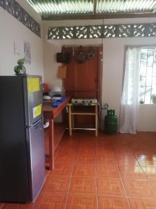 een keuken met een koelkast en een tafel bij El Güis hostel in Balgue