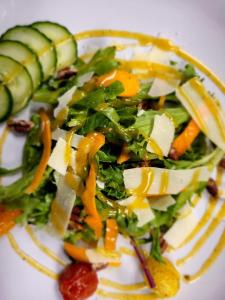 un plato blanco con ensalada con verduras y pepinos en Channel Bass Inn and Restaurant en Chincoteague