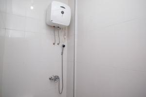 a shower with a shower head in a bathroom at RedDoorz Syariah near Alun Alun Temanggung in Temanggung +86 photos