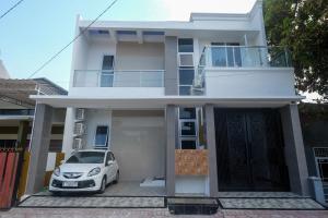 a house with a car parked in front of it at RedDoorz Syariah near Alun Alun Temanggung in Temanggung