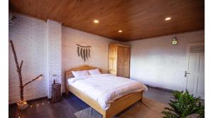 a bedroom with a large bed in a brick wall at Scent Village Hotel in Da Lat