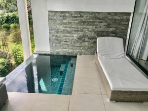 a swimming pool with a chair in a house at Stunning sea view villa Lamai Koh Samui in Lamai